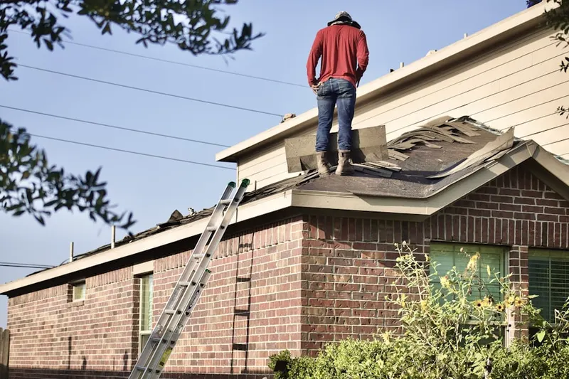 Professional roofer working on a residential roof in Arden-Arcade